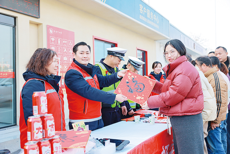 ▲高速公路收费站工作人员为司乘人员送祝福。