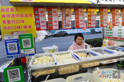 樊檢檢的攤子上寫著“我是聾人，麻煩請你指選擇需要的口味”等提示