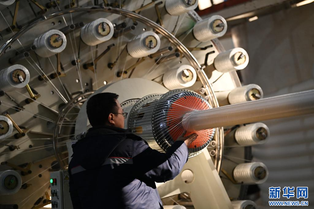 1月7日，在宝鸡天联汇通复合材料有限公司生产车间，工人查看柔性复合高压输送连续管设备运转情况。