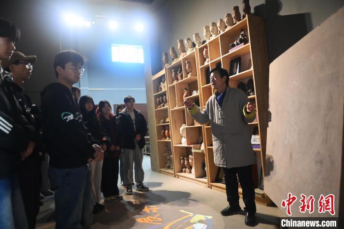 1月14日，甘肃省酒泉市，甘肃酒泉职业技术学院非物质文化遗产敦煌彩塑技艺传习所内，该校甘肃省级敦煌壁画技艺传承创新工作室负责人王权朝(右一)向学生们讲述敦煌文化。中新社记者　李亚龙　摄