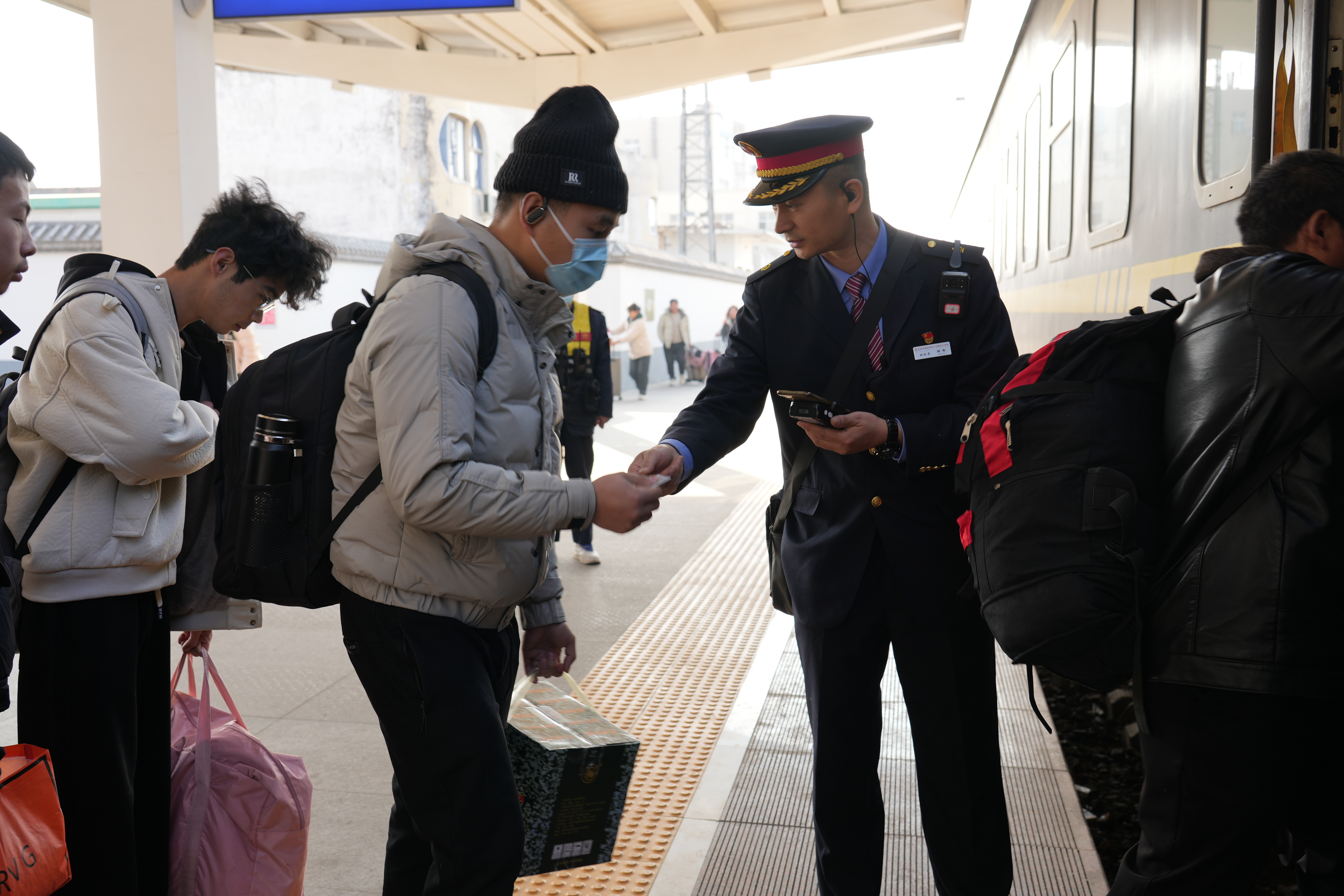 图为青年列车员在汝州站组织旅客验票乘车。李骞摄