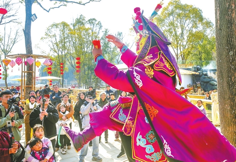 近日，游客們在武寧縣“一渡一山海”景區看川劇變臉等民俗表演。（蔣德先 潯陽晚報記者 楊羅軍 攝）