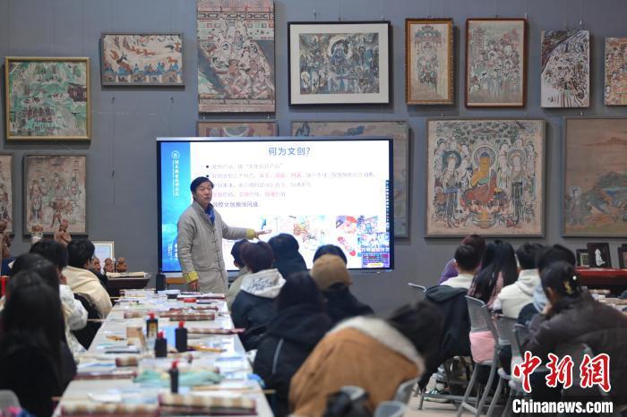 1月14日,在位于甘肃省酒泉市的酒泉职业技术学院非物质文化遗产敦煌彩塑技艺传习所内,教师王权朝正在为中外学子讲授敦煌壁画艺术与创作的相关课程。李亚龙 摄