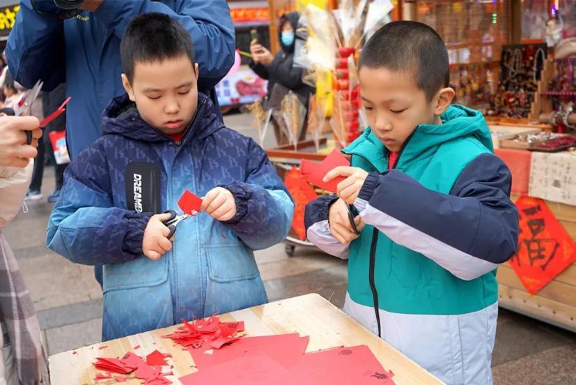 小朋友正在体验剪窗花。臧绍喜 摄