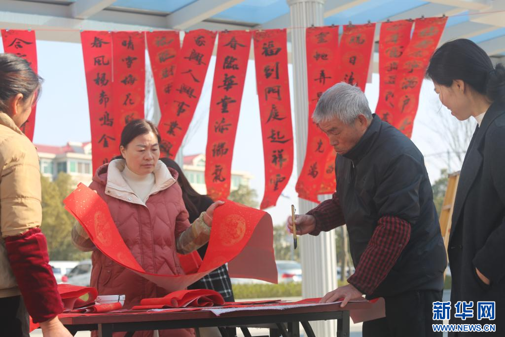 近日，吉安市青原區“寫春聯 過大年”活動現場，書法志愿者正在為群眾揮毫送福。新華網發 王永鋼 攝