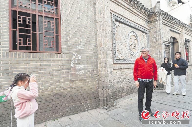 在芙蓉区白果园巷,一位外国游客带着小朋友在此游玩拍照。长沙晚报全媒体记者 邹麟 摄
