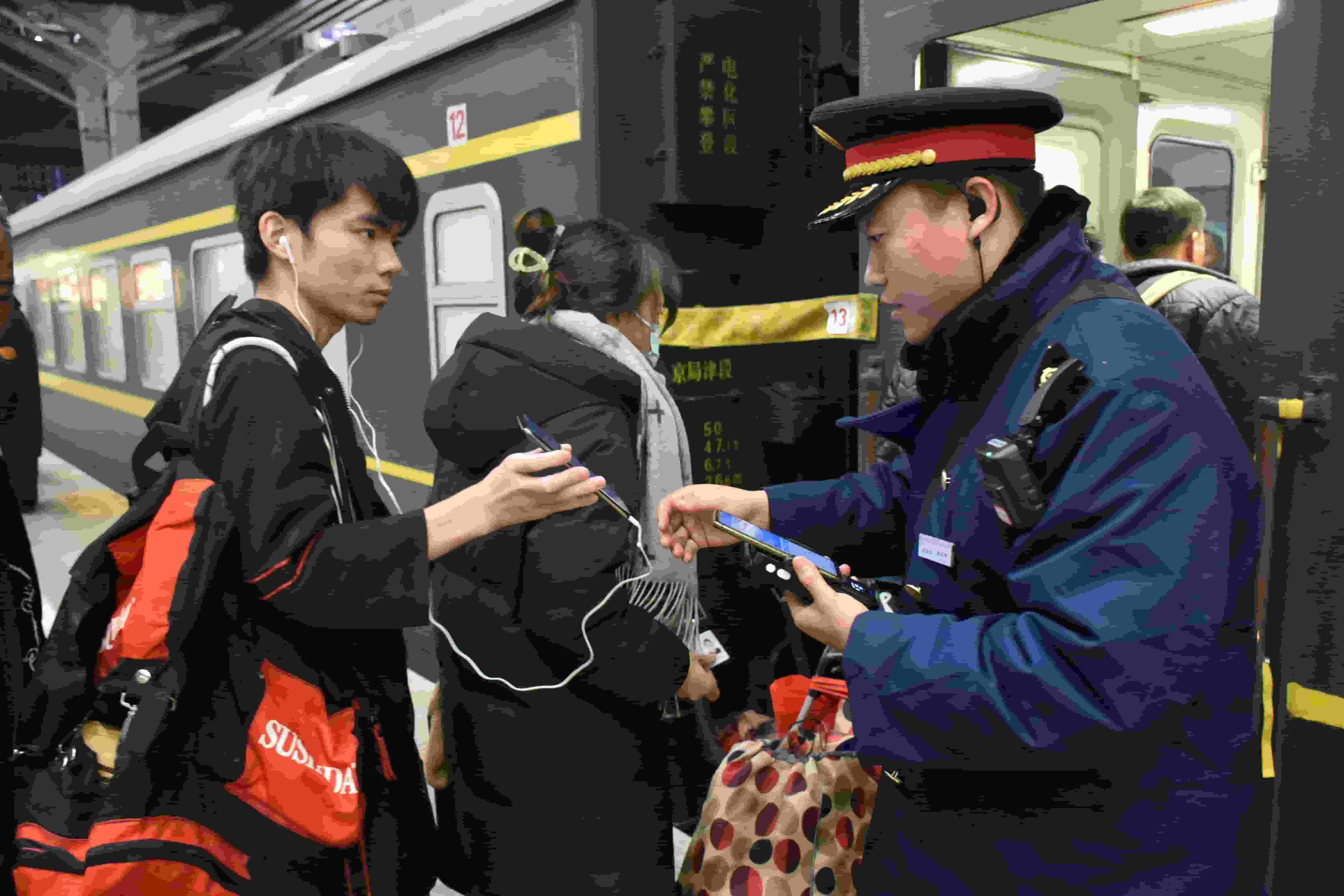 图为青年列车员在始发站北京西站组织旅客验票乘车。李骞摄