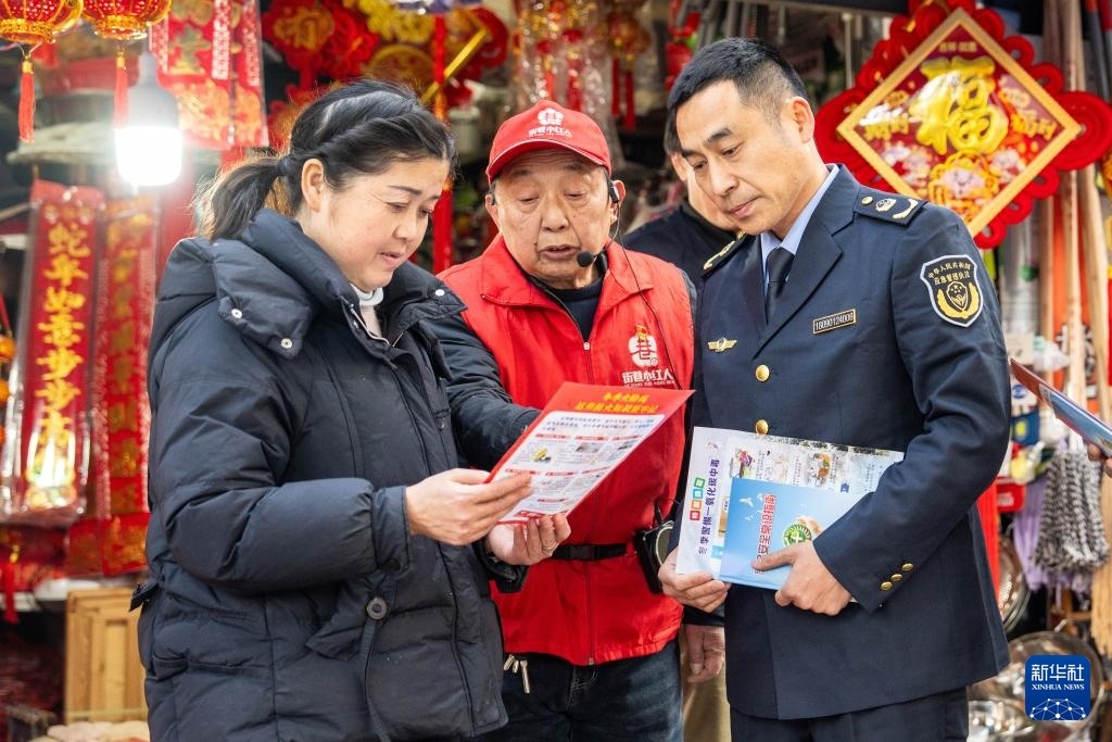 1月17日，在湖南省常德市武陵区丹阳街道紫桥社区，应急管理局工作人员联合社区志愿者向商户宣传冬季防火注意事项。新华社记者 陈思汗 摄