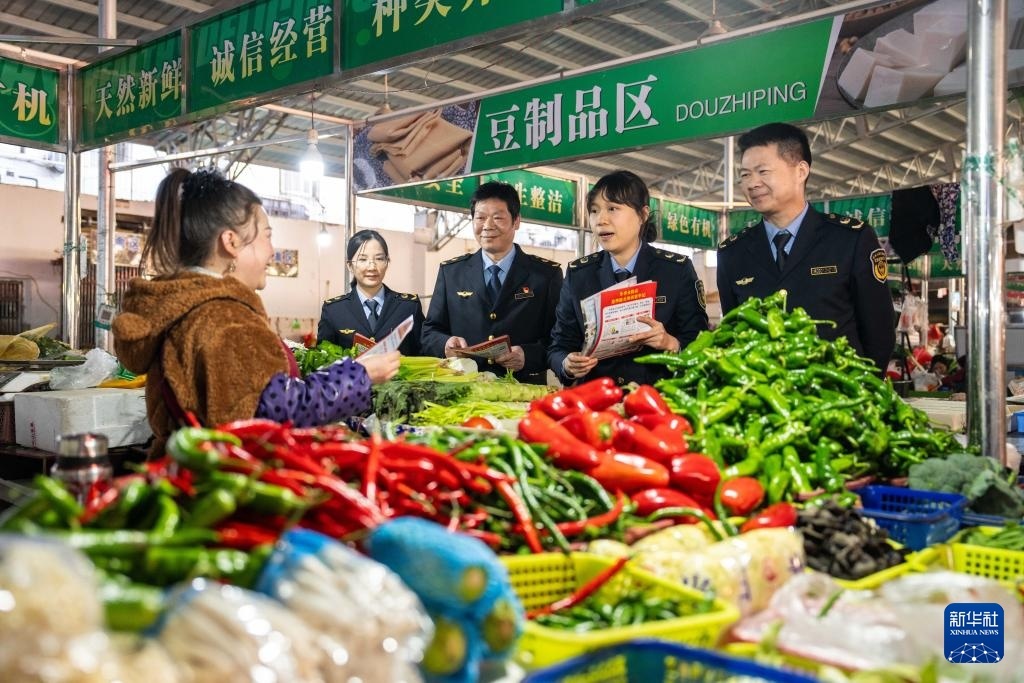 1月17日，在湖南省常德市武陵区南坪街道火车站农贸市场，应急管理局工作人员联合市场监管工作人员向商户宣传冬季防火注意事项。新华社记者 陈思汗 摄