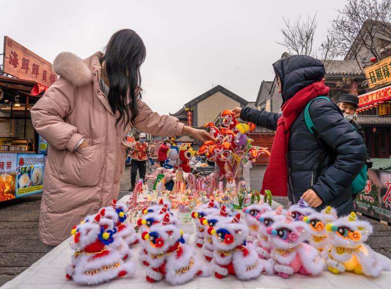 可爱的醒狮毛绒玩具吸引市民游客目光。武爱民 摄