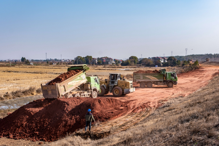 土方车正在堤防薄弱环节提升工程倾泄土方。刘远庆摄