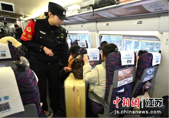 民警在列车上提醒旅客扶好行李箱。南京铁路公安处乘警支队供图