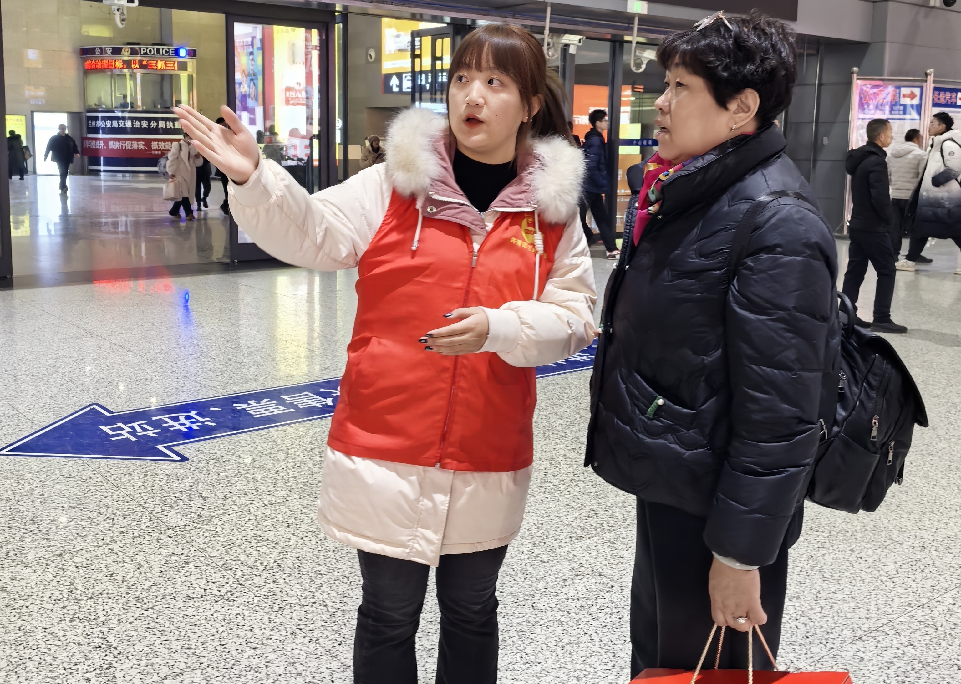 大学生志愿者为旅客指路