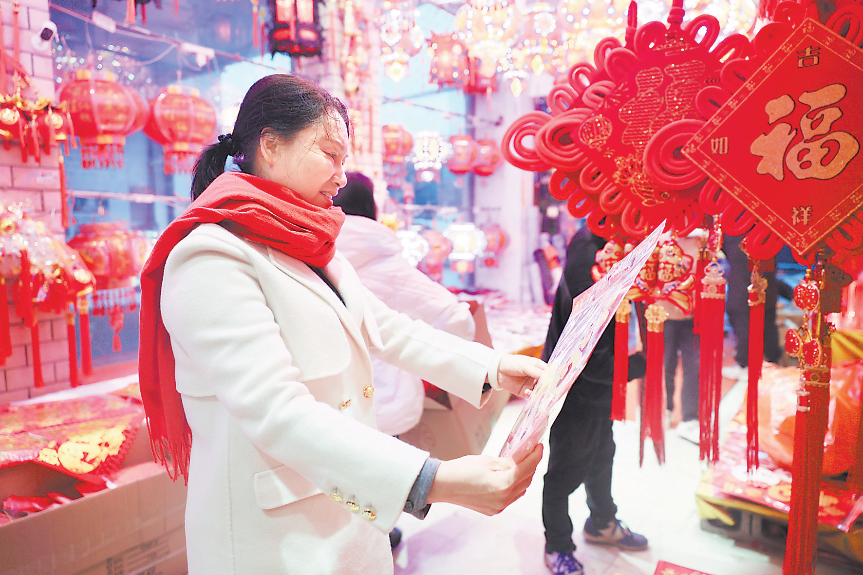 新春佳节将至，市城区一年画店内，市民在精心选购心仪的春联、“福”字、中国结等年货。见习记者王啸晖 摄
