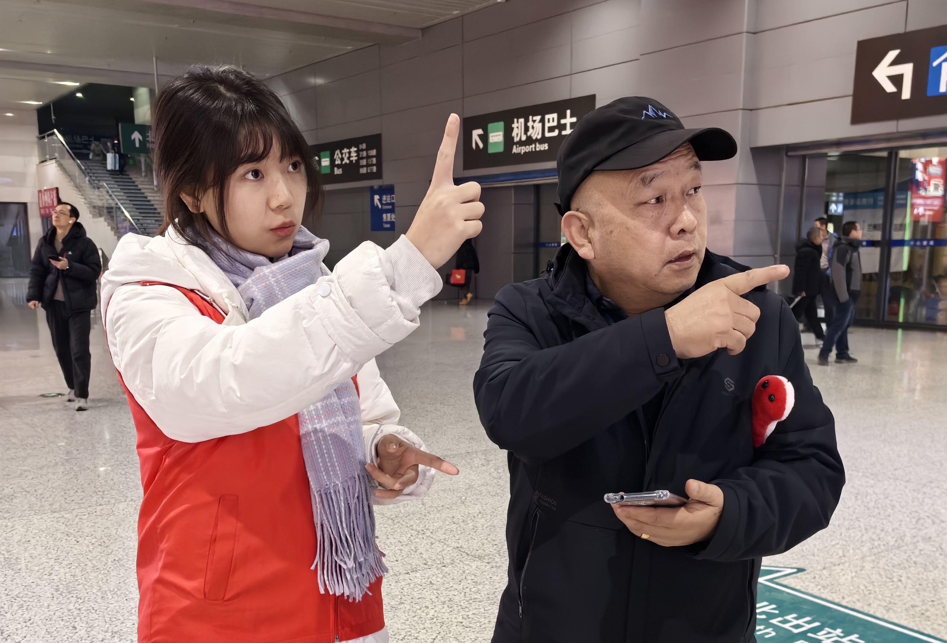 大学生志愿者为旅客指引公交车乘车方向