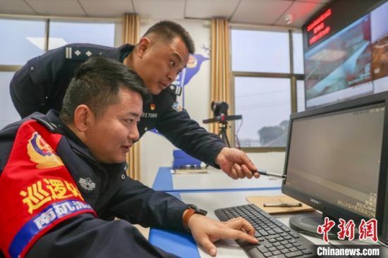 图为南矶派出所的所长刘万里(图上)和副所长徐亦戈(图下)在派出所内通过视频监控设备对湖区进行巡查。刘力鑫 摄