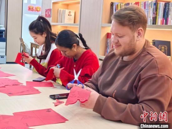 图为外国留学生在江西省南昌市南昌县金湖管理处玉岸社区学习剪纸。胡琦 摄