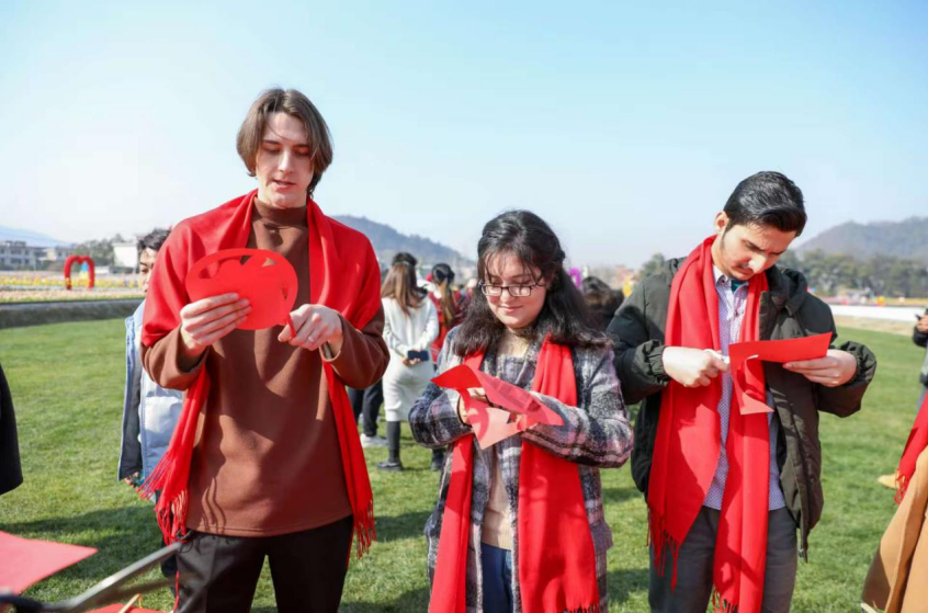 外国留学生正在袁州区彬江花海对花剪“花”，现场临摹剪纸艺术。( 袁州区委宣传部供图）