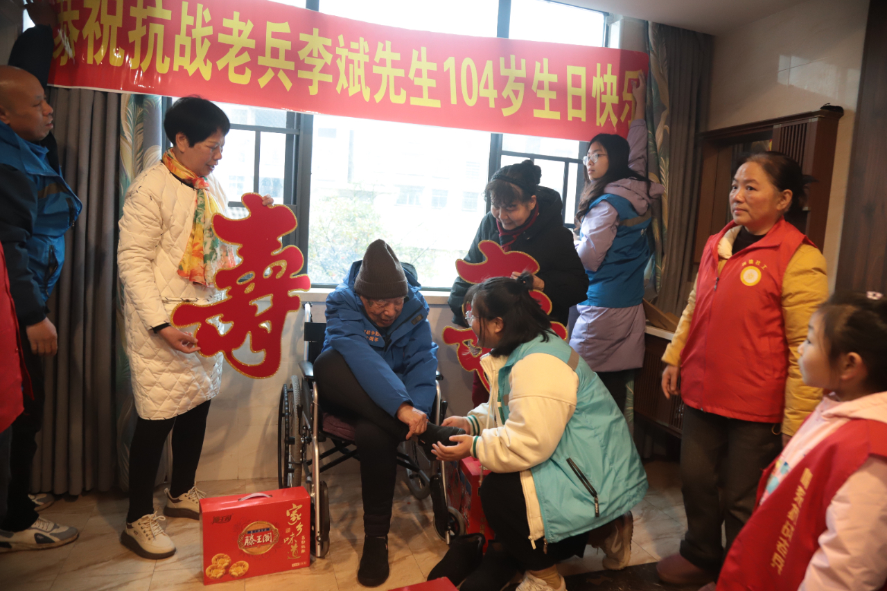 邵阳当地的志愿者正在为李斌试穿浔阳区退役军人事务局寄出的鞋子