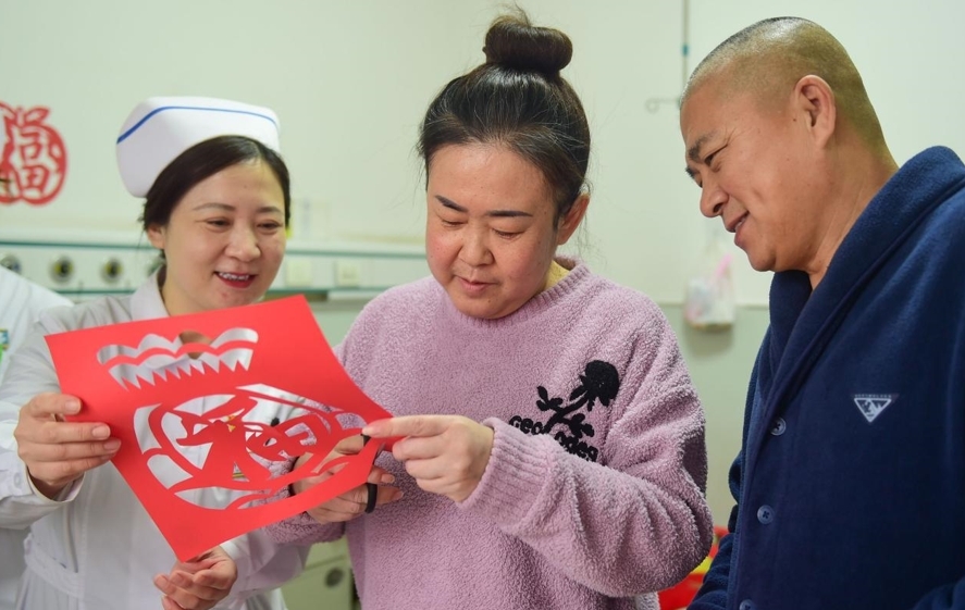 1月26日，沧州市第三医院肝病二科的医务人员与患者朱芸剪窗花——“福”字。