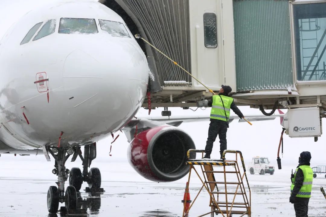 兰州机场机务人员正在为出港航班清理积雪　陈吉扬　摄