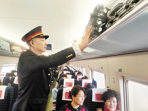 1月25日，在G7818次列车上，张念念正在整理行李架上的行李。本报记者 方素菊摄