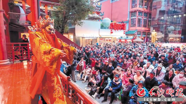 新春庙会上，穿着大红袍的“财神”向游客送新年红包。长沙晚报全媒体记者 陈飞 摄