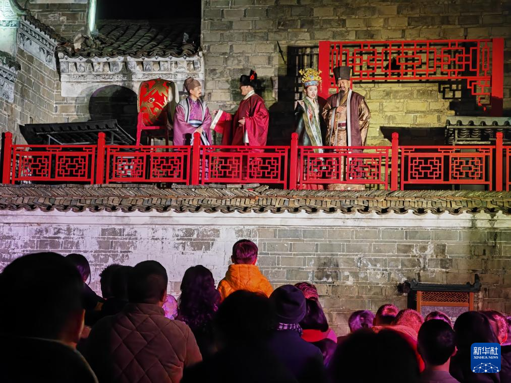 2025年2月3日晚，游客在江西省抚州市乐安县古樟林旁的流坑古村欣赏沉浸式演出《流芳》。新华社记者 刘红霞 摄