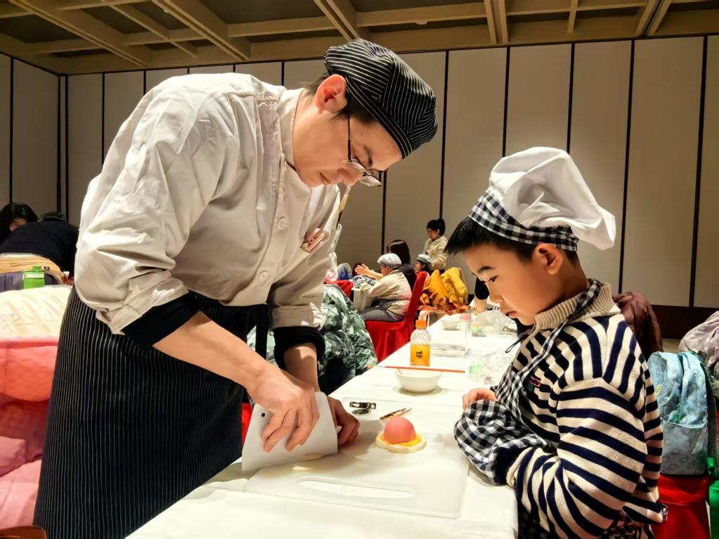 陕菜文化体验博物馆的老师教研学学员做非遗花馍。新华社记者 蔡馨逸 摄