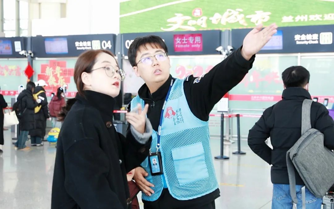 兰州机场“雷锋安检”工作人员引导旅客进行安检　张斌　摄
