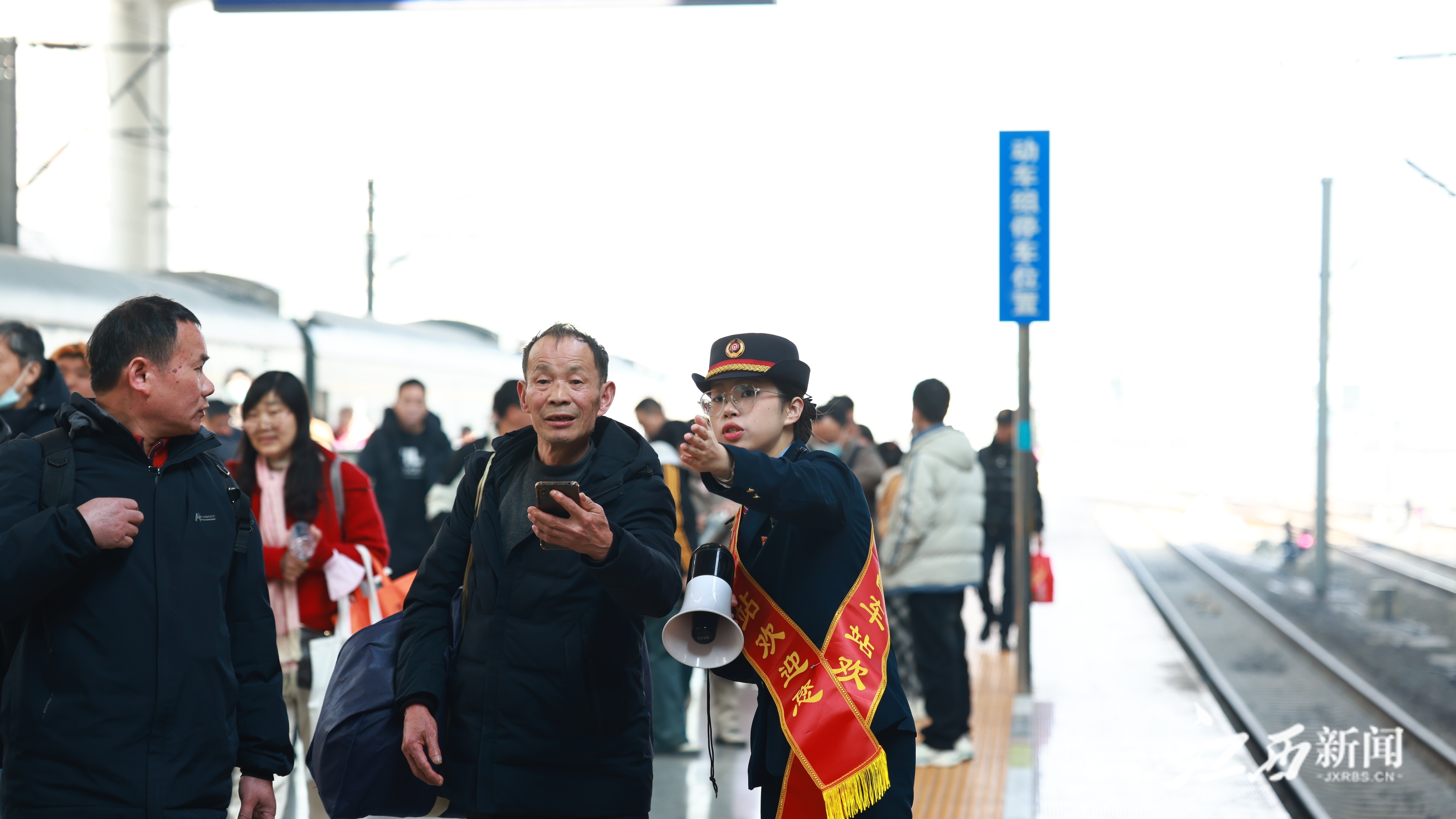 ▲南昌站客运员为到达旅客指引中转换乘通道 张倩 摄