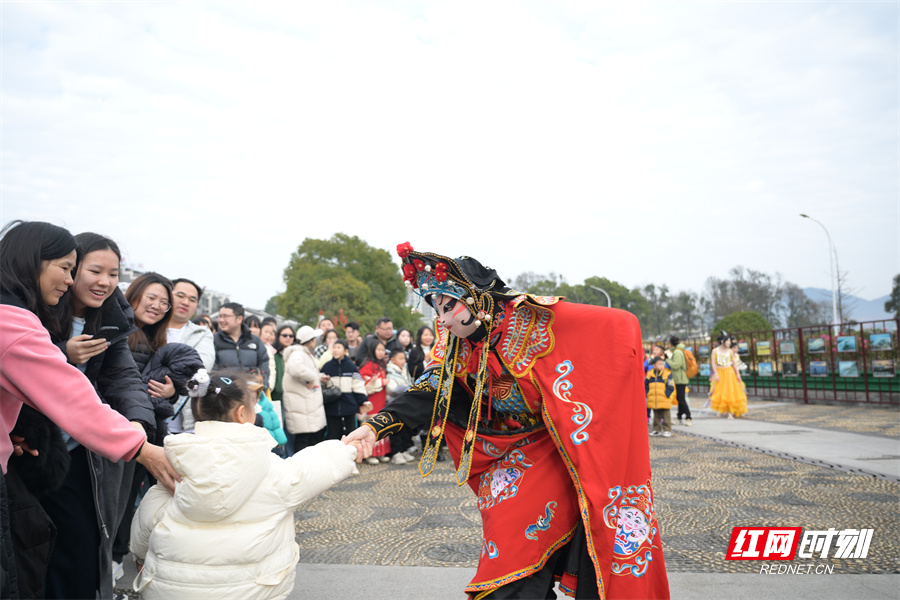 1月30日，游客在资兴市东江湖旅游区欣赏川剧变脸。