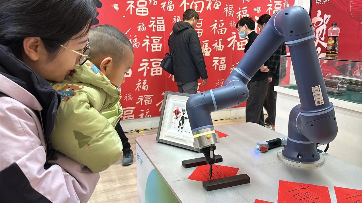 埃斯顿机器人在南京南站为旅客写“福”字