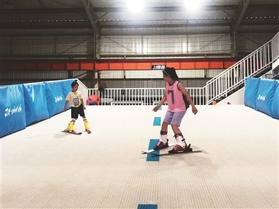 孩子们在旱雪运动场馆学滑雪