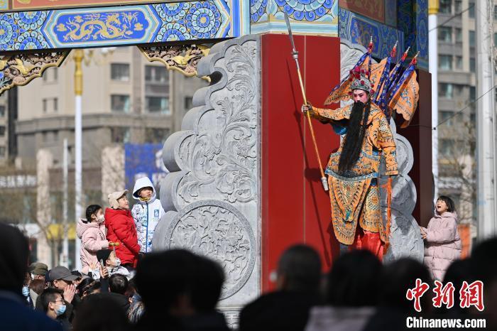2月12日,甘肃兰州老街,高跷表演者吸引小朋友目光。当日是农历正月十五元宵节,兰州老街举行丰富多彩的社火展演,迎接元宵节的到来。中新社记者 九美旦增 摄