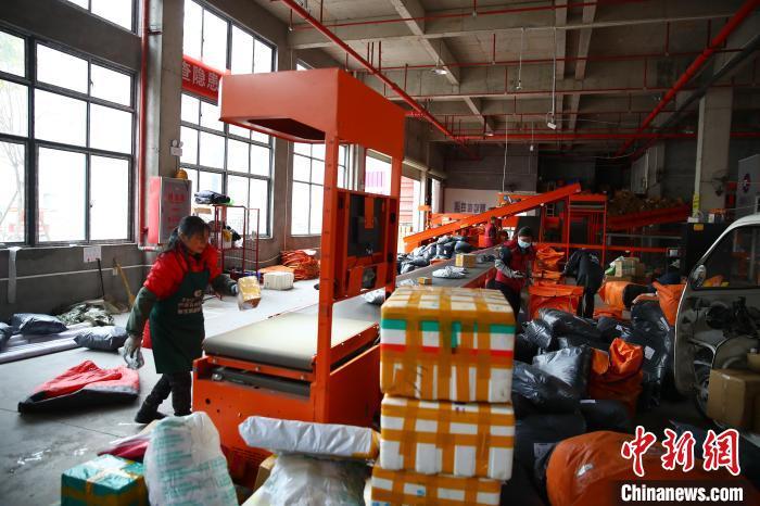 2月8日,在江西供销(广昌)数字物流产业园的一家快递企业转运中心,快递工作人员整理快递包裹。记者 刘占昆 摄