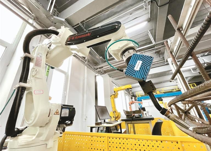 在高新区的西安知象光电科技有限公司的先进三维视觉技术研究中心内，工业机器人在3D相机“双眼”的引导下，正在对钢构组件进行自动化焊接。 （资料图片）