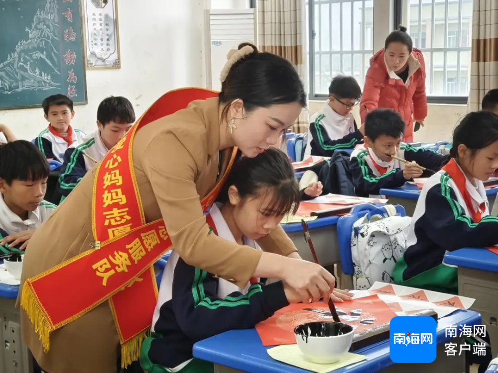 志愿者帮助孩子们练习书法。海南省妇联供图