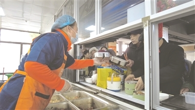 春节前夕，月湖区立新社区幸福食堂里老人们正排队取餐。　　 本报记者 朱烈闯摄