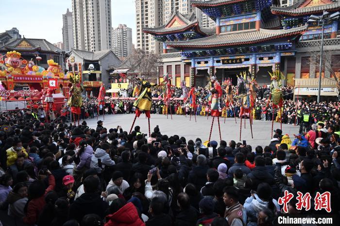 2月12日,甘肃兰州老街,高跷表演吸引民众驻足观赏。当日是农历正月十五元宵节,兰州老街举行丰富多彩的社火展演,迎接元宵节的到来。中新社记者 九美旦增 摄