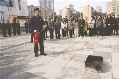 图为消防人员正在讲解干粉灭火器的使用方法。通讯员 辛佩佩摄