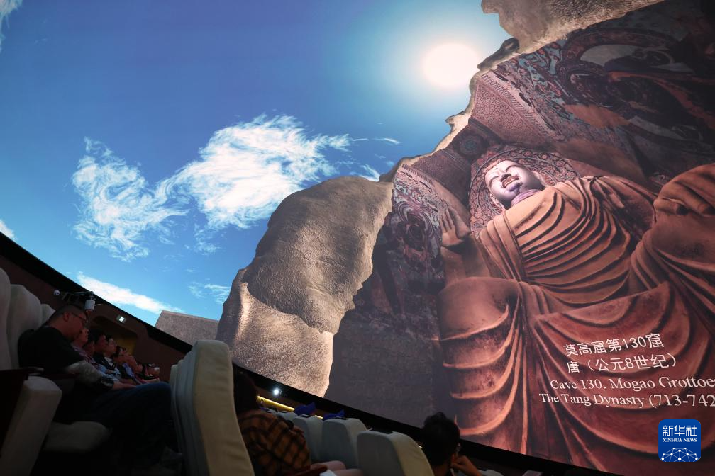 2024年9月4日,游客在莫高窟数字展示中心观看球幕电影《梦幻佛宫》。新华社记者 陈斌 摄