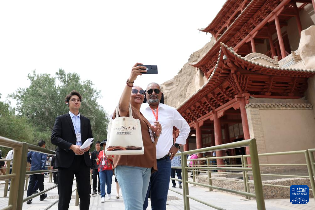 2024年6月7日,前来甘肃调研考察的驻华外交官在敦煌莫高窟九层楼前留影。新华社记者 陈斌 摄