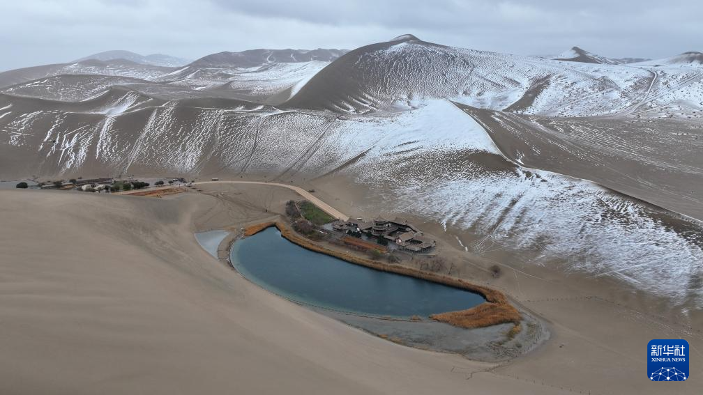 这是2014年11月23日拍摄的敦煌市鸣沙山月牙泉景区雪景(无人机照片) 新华社发(张晓亮 摄)