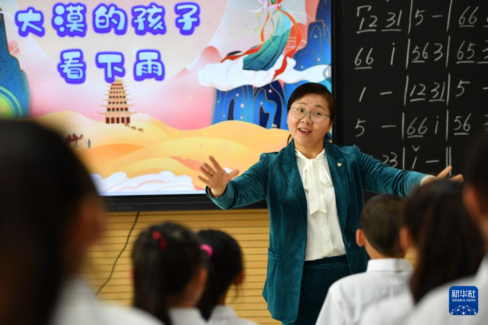2023年4月26日,在敦煌市西关小学,音乐教师罗莉在课后服务时间指导合唱团的学生练习合唱敦煌特色歌曲。新华社记者 陈斌 摄