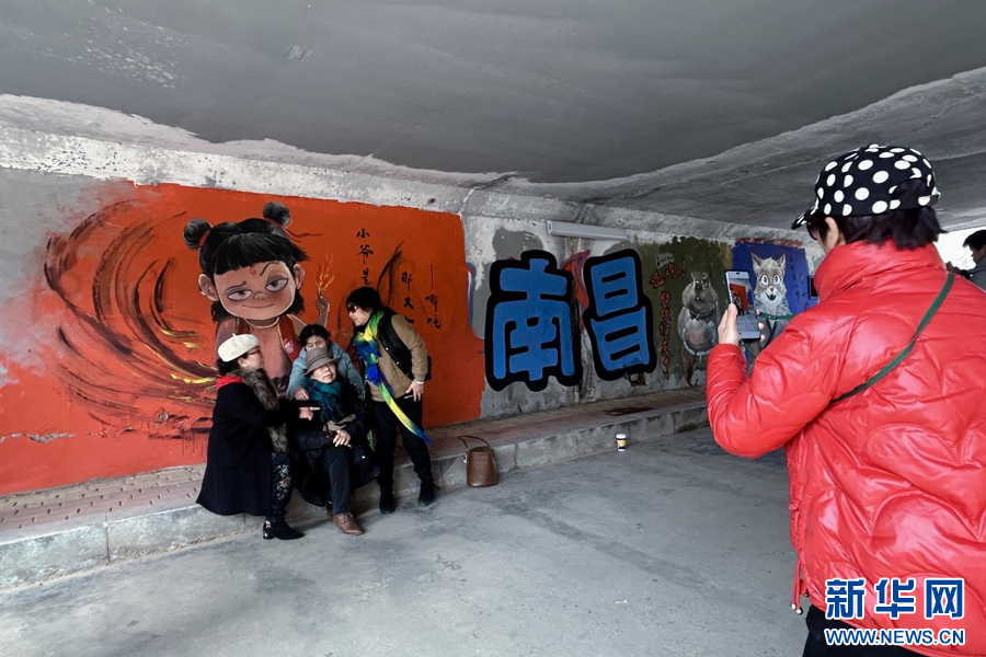 游客们在哪吒主题涂鸦墙前打卡拍照。新华网发 欧阳仟 摄