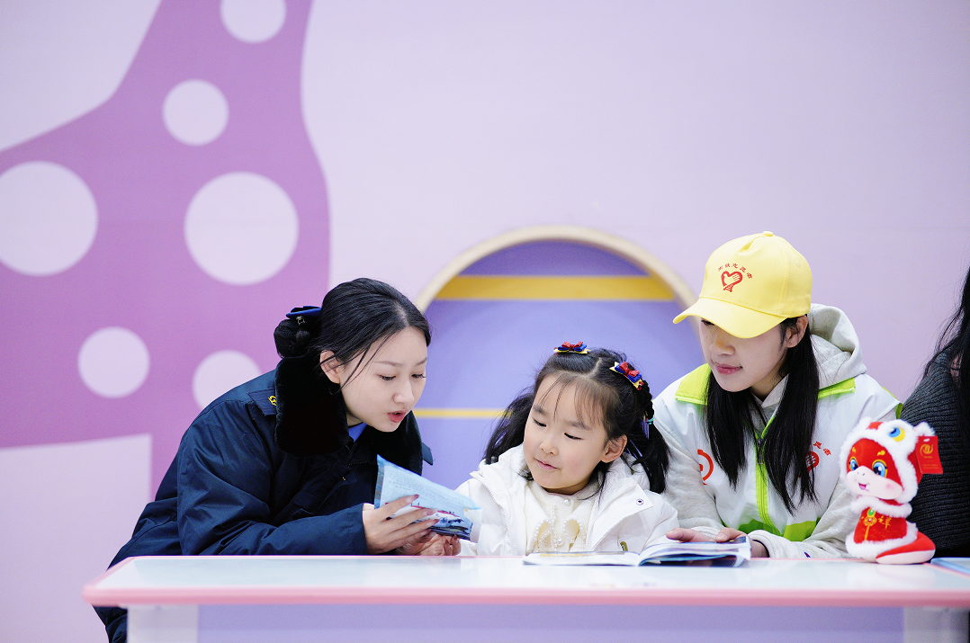 春运首日，赣州西站工作人员在“萌娃驿站“帮助照看小旅客。（刘立 摄）