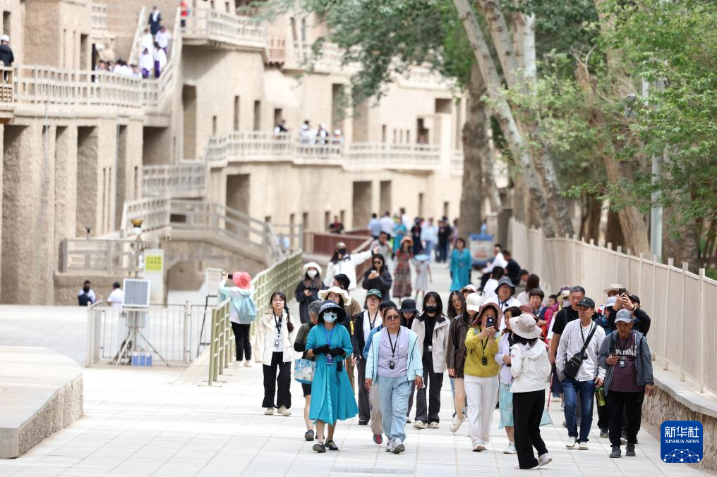 2024年6月7日,游客在莫高窟参观游览。新华社记者 郎兵兵 摄