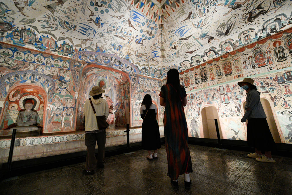 2024年6月7日,在敦煌石窟文物保护研究陈列中心,游客参观莫高窟复制洞窟第276窟壁画。新华社记者 郎兵兵 摄