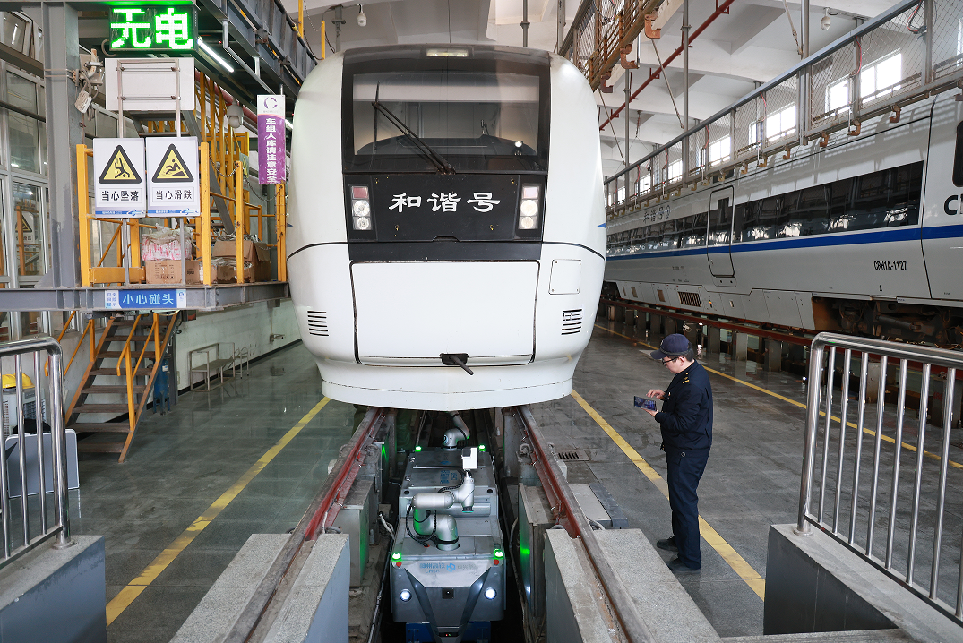 福州动车段动车组机械师正在操作智能检修机器人检查动车组。（董毅 摄）